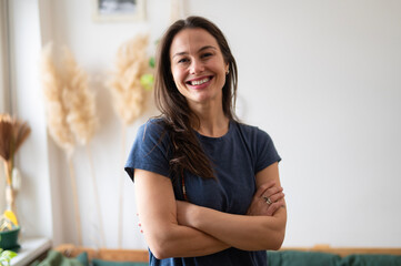 Happy woman standing with arms crossed smiling confidently