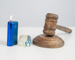 Judge's gavel and electronic cigarette. Smoking ban. Tobacco heating systems. 