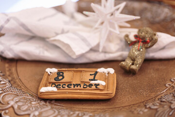 Gingerbread calendar with December 31 date and festive decorations including star ornament and golden teddy bear