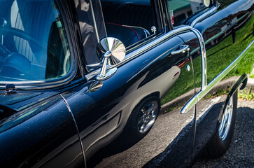 Close-up view of a classic car showing reflections it's shiny paint,