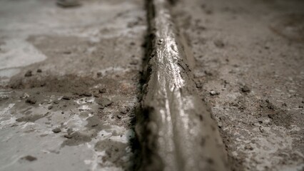 Close-up of wet cement mortar drying and hardening on a concrete surface. The texture of the fresh building material during construction