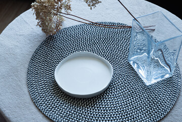 Empty ceramic plate on table with woven placemat