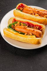 Hotdog fried onions, sausage, bun, sauce fast food tasty snack fresh delicious gourmet food background on the table rustic top view copy space