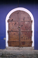 An old door on a wall painted purple