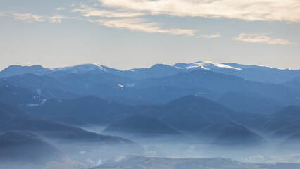 Misty mountain range with snow-capped peaks. The Velka Fatra national park in northwest of Slovakia, Europe.