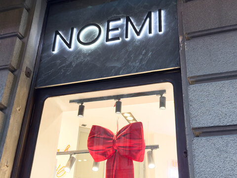 Zagreb, Croatia - December 14, 2025: Storefront of Noemi boutique featuring elegant red bow decoration, showcasing stylish window display with modern lighting and inviting ambiance