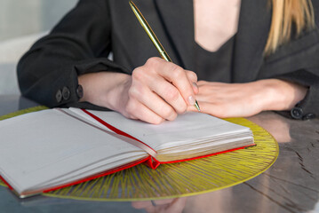 Close-up of a hands holding a pen and a notebook.