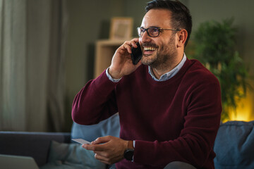 Man making secure online payment with smart phone and credit card at home