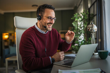 Man in headset having online video call from home office