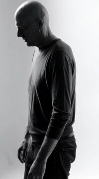 Homem Careca Caminhando Cabisbaixo com Expressao de Tristeza Emocional e Solidao