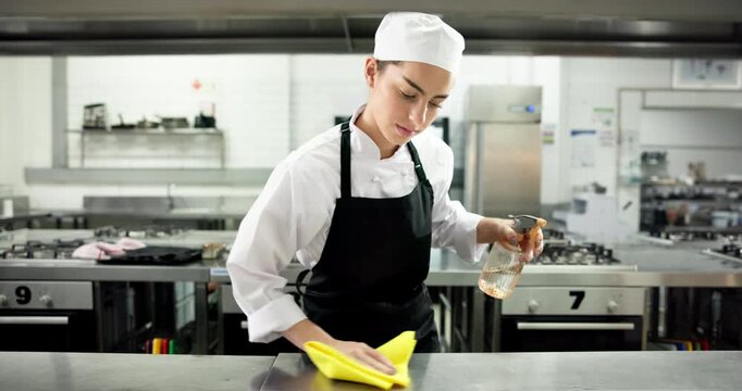 Chef, woman and spray for kitchen counter at restaurant, wipe or hygiene with sanitation process for germs. Person, cloth and bottle with chemical, liquid and cleaning product for bacteria at diner
