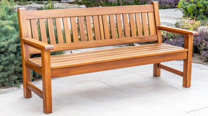 Wooden garden bench with engraved memorial plaque surrounded by plants and paving