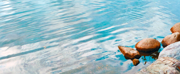 Soft Ripples of Teal Water Breaking at the Shoreline by Rocks
