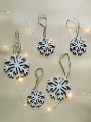 White snowflake Christmas ornaments near "Dew" garland