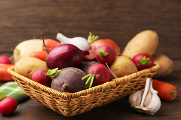Different raw vegetables on wooden table, closeup