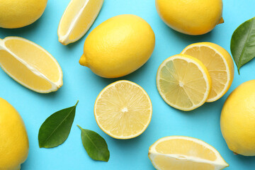 Fototapeta premium Fresh ripe lemons and leaves on light blue background, flat lay