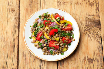 Tasty salad with lentils and vegetables on wooden table, top view