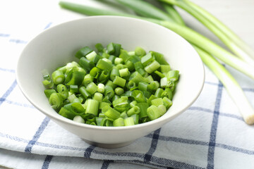 Whole and cut fresh green onions on table, closeup