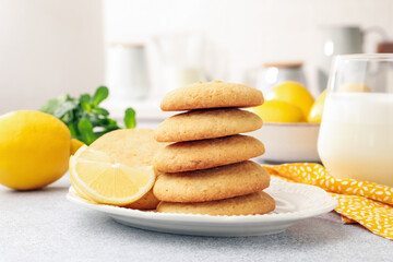 Tasty lemon cookies, milk and fruits on light table, closeup