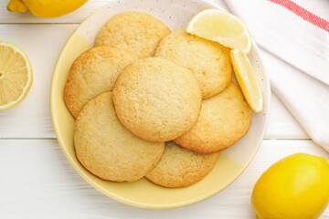 Tasty lemon cookies and fruits on white wooden table, flat lay