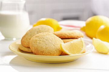 Tasty lemon cookies, milk and fruits on white wooden table, closeup