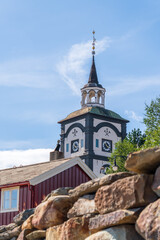 Charm of R&oslash;ros church stands tall above buildings in the historic mining town, attracting visitors and tourists with its unique architecture and serene atmosphere in Norway.