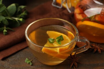 Aromatic tea with fruits, spices and mint on wooden table, closeup