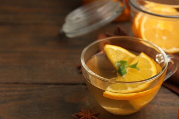 Aromatic tea with fruits, spices and mint on wooden table, closeup. Space for text