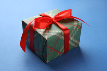 Beautiful gift box on blue background, closeup