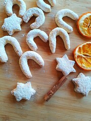 Fresh homemade holiday cookies with sugar powder, dry oranges and spices, Christmas cookie background