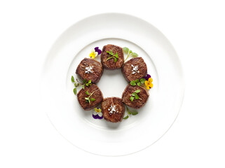 Exquisite Presentation of Gourmet Beef Medallions Garnished with Edible Flowers in Elegant Dish