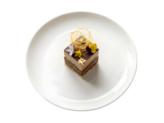 Deliciously Artful Chocolate Dessert with Edible Decorations and Flowers on a White Plate