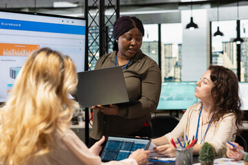 Goals oriented black leader presenting insights on monitor for a strategic collaboration in office, using TV and data reports to build strong goals alignment and inspire achievement.