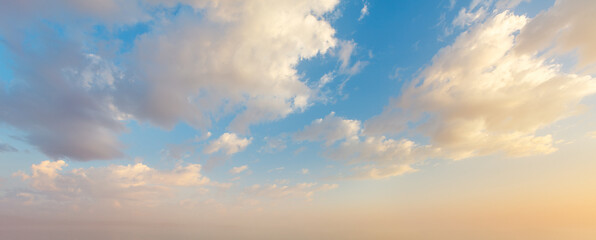 Dramatic sunset sky with vibrant colors and fluffy clouds over horizon