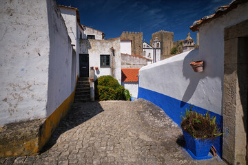 Narrow streets and white houses in Obidos medieval town in Portugal