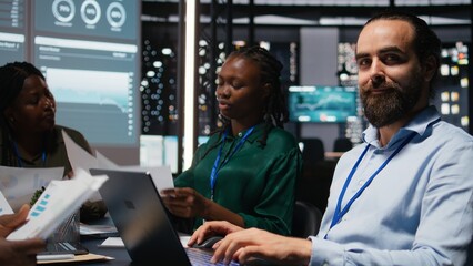 Male accounting manager reviewing budget numbers after all monthly costs, reviewing data updates on laptop during night time meeting with his work team. After hours night scene. Camera A.