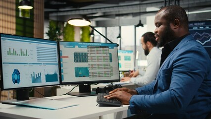 African american office worker leverages analytics and report writing for development and monthly performance results, resources and insights to ensure strategic goals achievement.