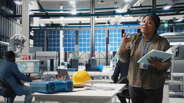 Professional female presenter discusses green energy business investment in a high tech solar panel plant, showcasing innovation for eco friendly sustainable solutions. Marketing ad. Camera A.