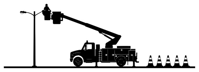 Utility worker in bucket truck repairing street light with safety cones