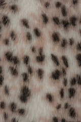 Macro photo of a leopard-colored faux fur coat as a background.