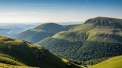Rolling green hills and mountains under clear blue sky