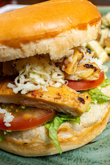 Grilled Chicken Sandwich with Melted Cheese, Lettuce and Tomato on Toasted Bun, Close Up Food Photography