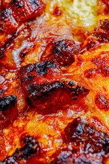 Close-up of a slice of pizza with crispy pork rinds, ripe plantain, shredded beef, chorizo sausage, and guacamole.