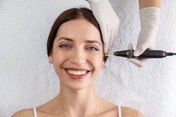 Woman undergoing microneedling procedure in beauty salon, top view