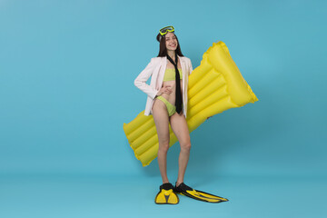 Businesswoman with diving mask, air mattress and flippers on light blue background, space for text © New Africa