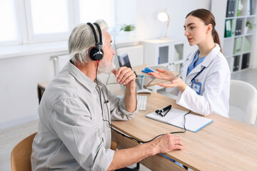 Patient with audiometric headphones undergoing hearing test in clinic © New Africa