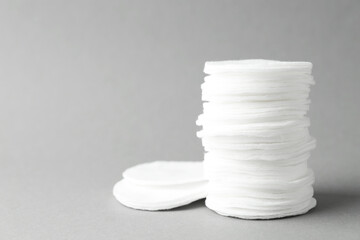 Stack of clean cotton pads on light grey background, closeup. Space for text © New Africa