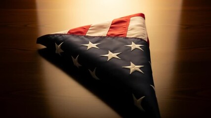 Memorial folded flag unveiling with dramatic lighting and soft wooden surface texture transition - Powered by Adobe