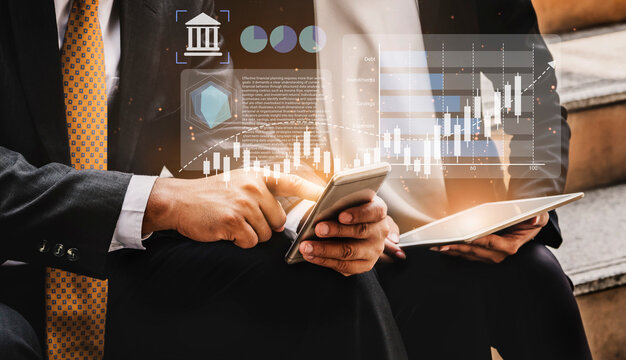 Business professionals engage in financial analysis using digital devices. They explore data trends through graphs and charts, enhancing decision-making and strategy development. Gantry - Powered by Adobe