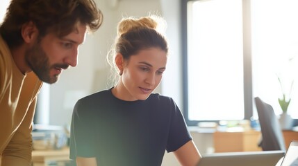 Two professionals collaborate at a desk focusing on workplace communication, mentorship, and modern teamwork. Image supports business training, leadership development and office productivity themes